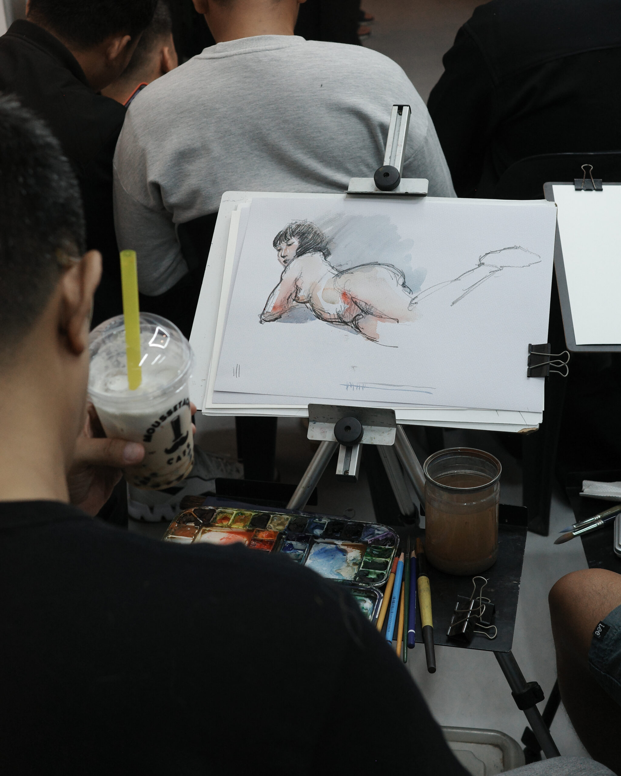 artist holding Moussetache Cafe while drawing