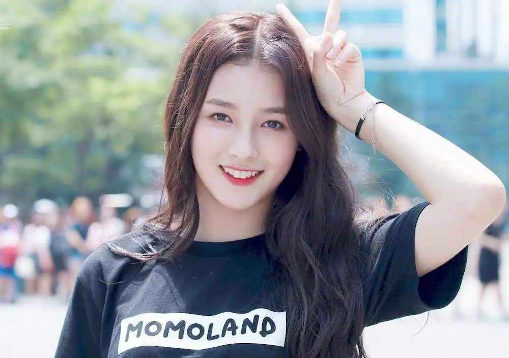Nancy Mcdonie posing for a picture wearing momoland shirt