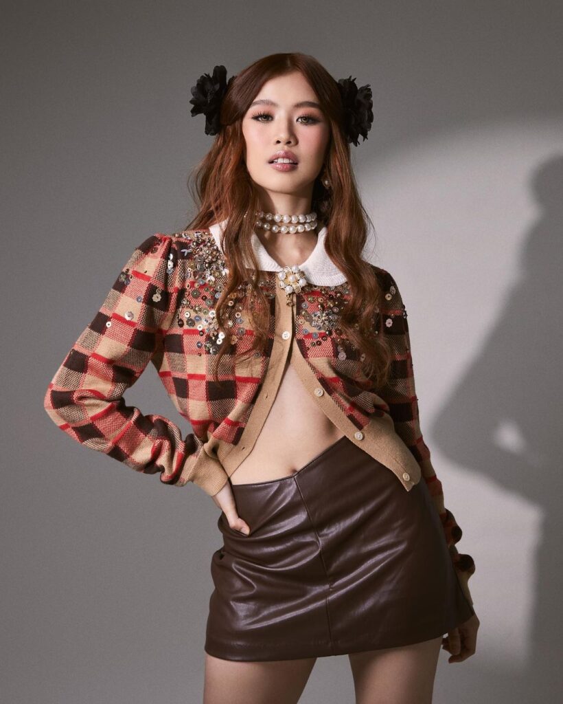 Bini Maloi wearing cardigan and brown leather skirt