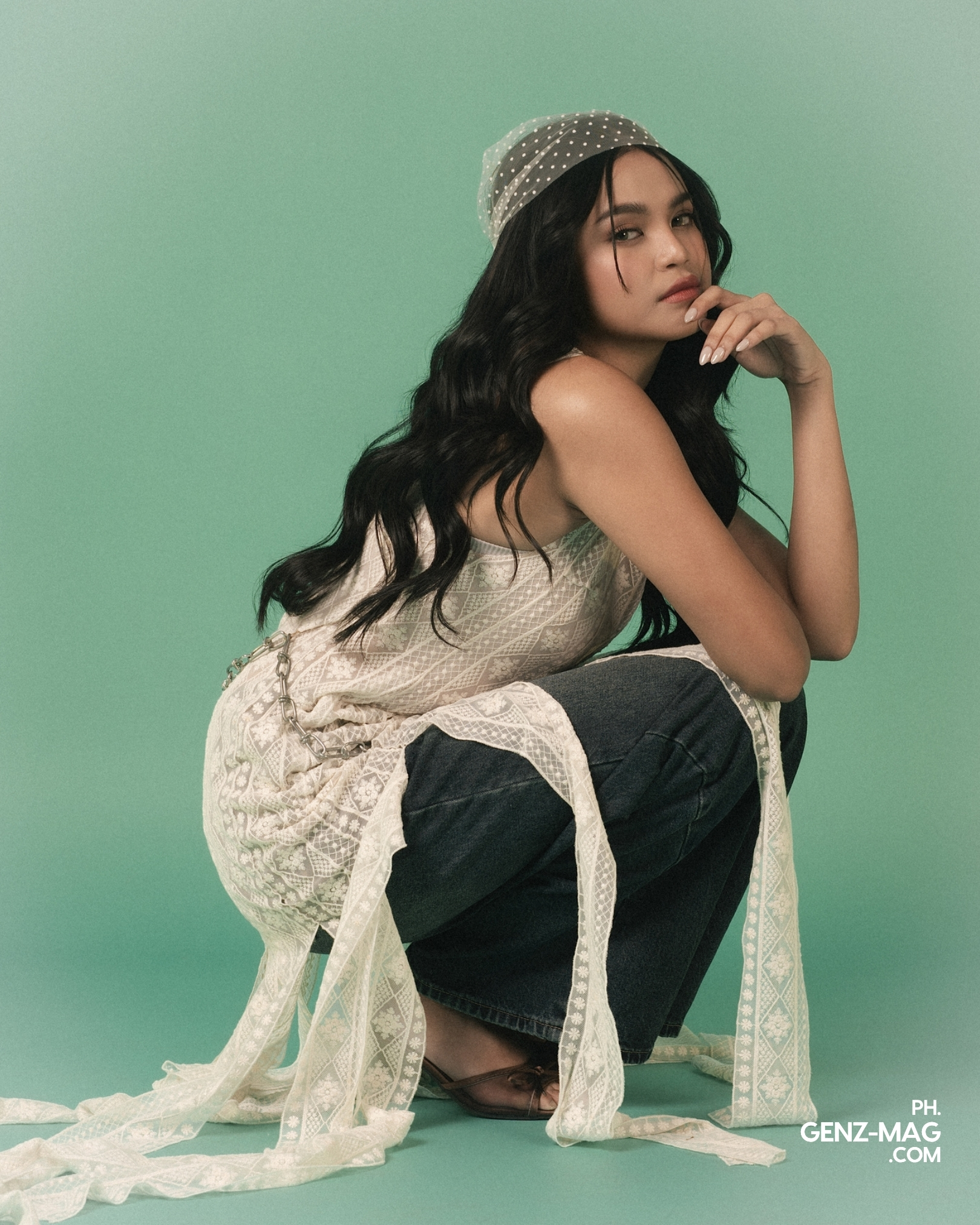 Alt text: "Zephanie crouched with her chin resting on her hand, wearing a lace top with a chain belt and wide-leg denim, for GEN Z Magazine's cover story with Michael Sager
