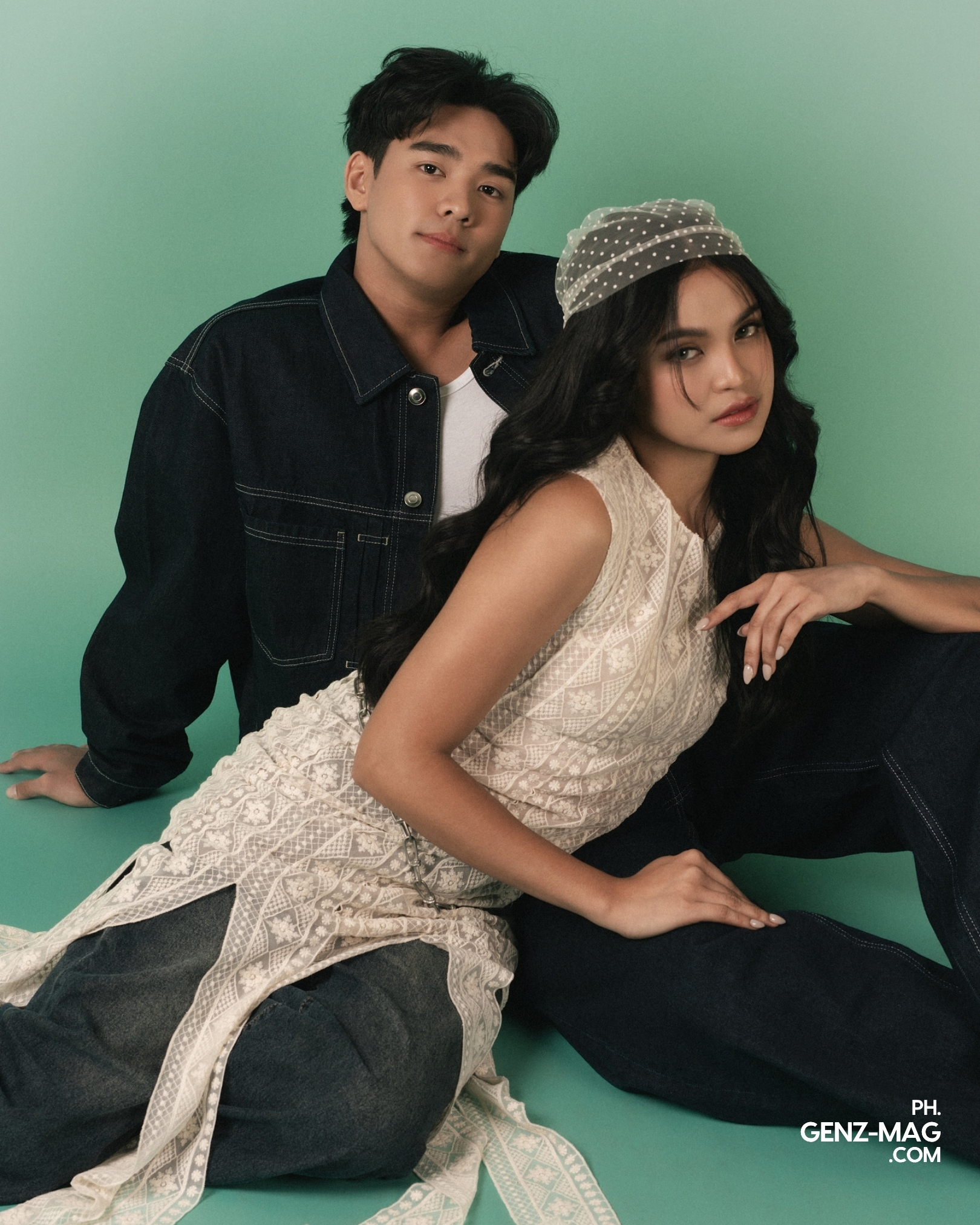 Michael Sager and Zephanie seated together against a sage green backdrop, Michael in a denim jacket and Zephanie in a lace top with a polka-dot headscarf, shot at The Villa Studios, for GEN Z Magazine's cover story