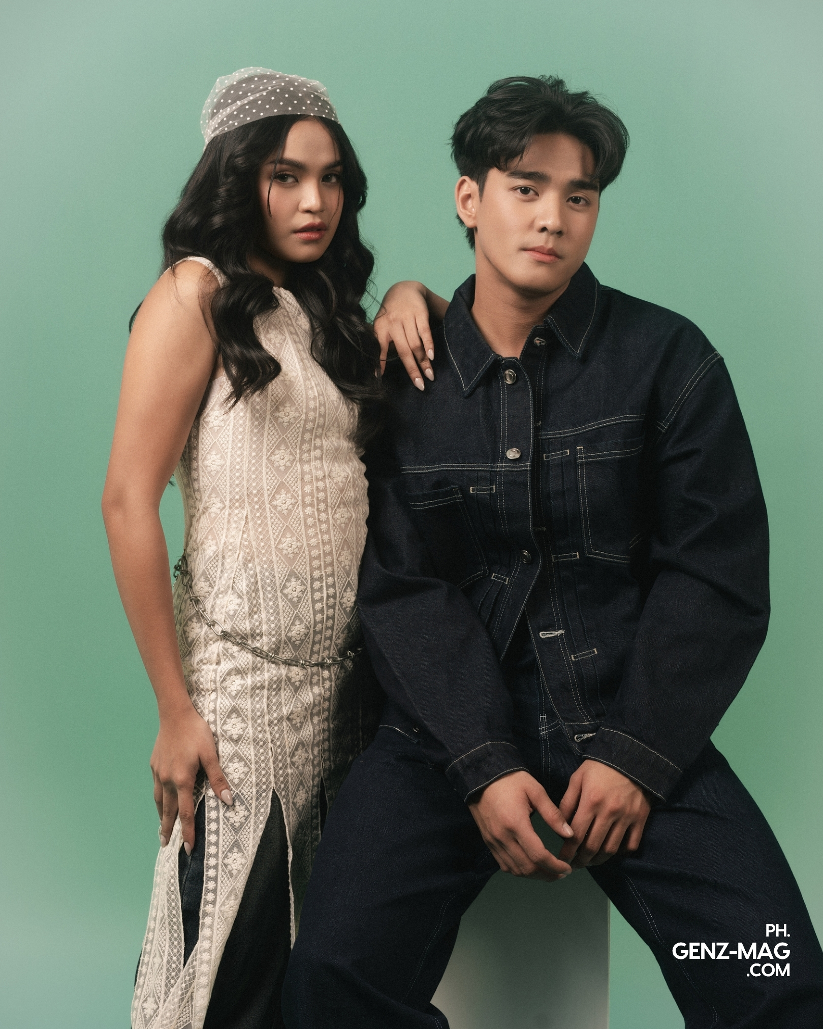 Zephanie resting her hand on Michael Sager's shoulder, both facing the camera in a lace dress and denim jacket against a sage green backdrop, shot at The Villa Studios, for GEN Z Magazine's cover story
